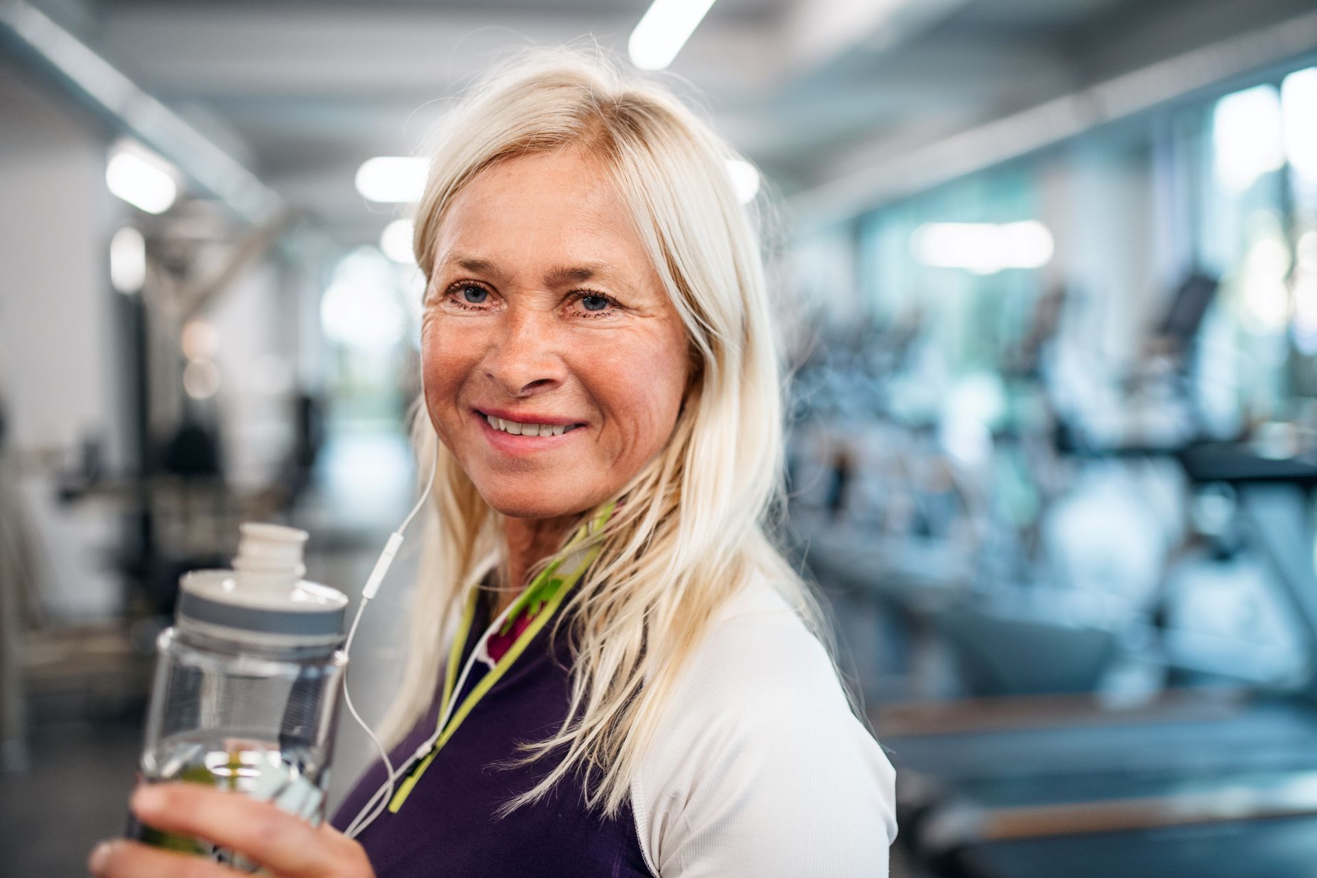 a senior woman with earphones and water bottle sta 2024 10 18 09 09 18 utc